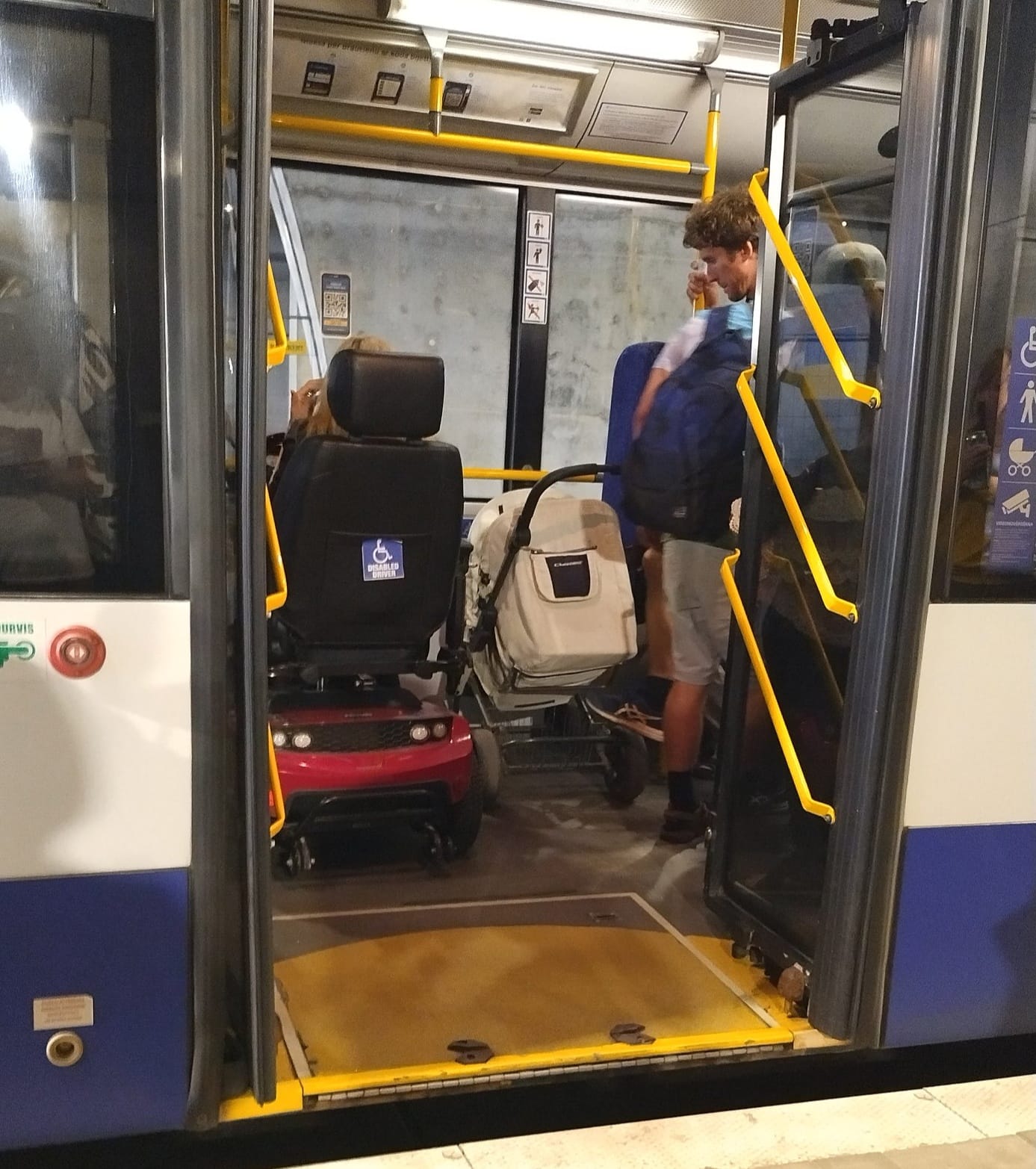 Sieviete ratiņkrēslā un bērnu ratiņi autobusā